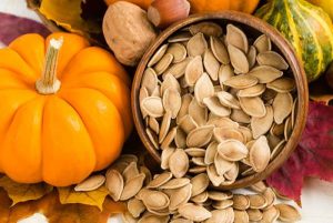 تصویری از تخم کدو تازه در ظرف چوبی برای معرفی خواص آن